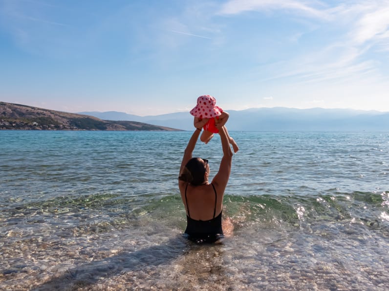 Mutter mit Kleinkind im Meer der Insel Krk, Kroatien.