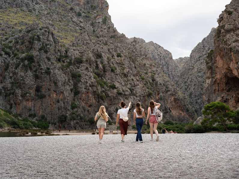 Vier Freundinnen laufen zusammen am Strand