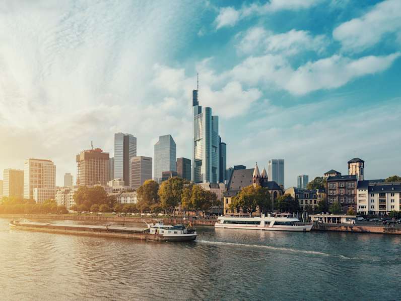 City At Waterfront Against Cloudy Sky
