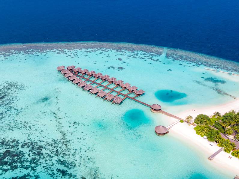 Luftbild eines Atolls mit Wasserbungalows