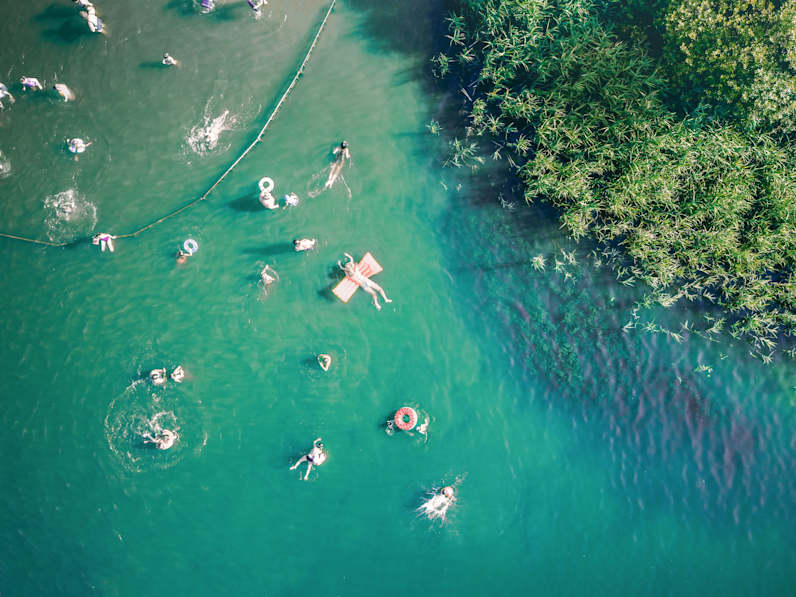 Menschen im See mit Luftmatratzen