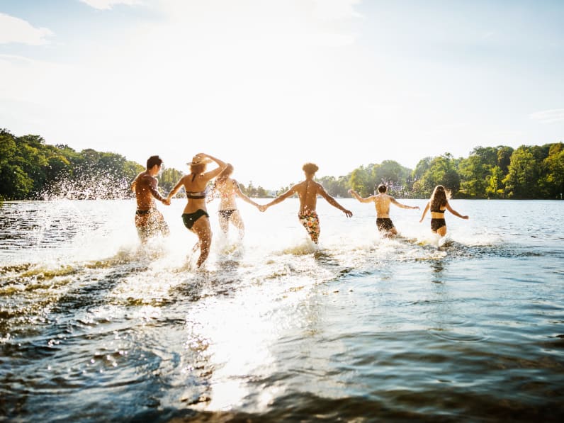 Freunde laufen in einen Badesee