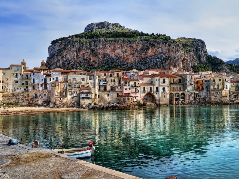 Sea By Old Buildings In Cefalu Against Sky