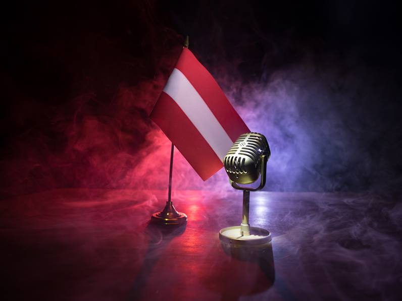 Mikrofon auf dem Hintergrund einer unscharfen Flagge Österreichs © zef art