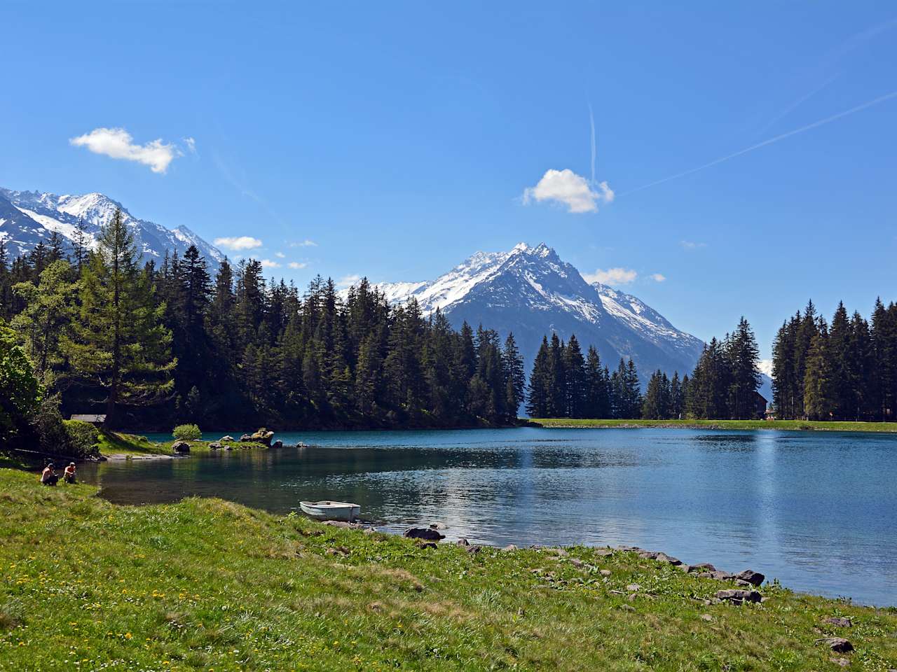 Blick vom Ufer des Arnisees auf die hohen Berge im Hintergrund