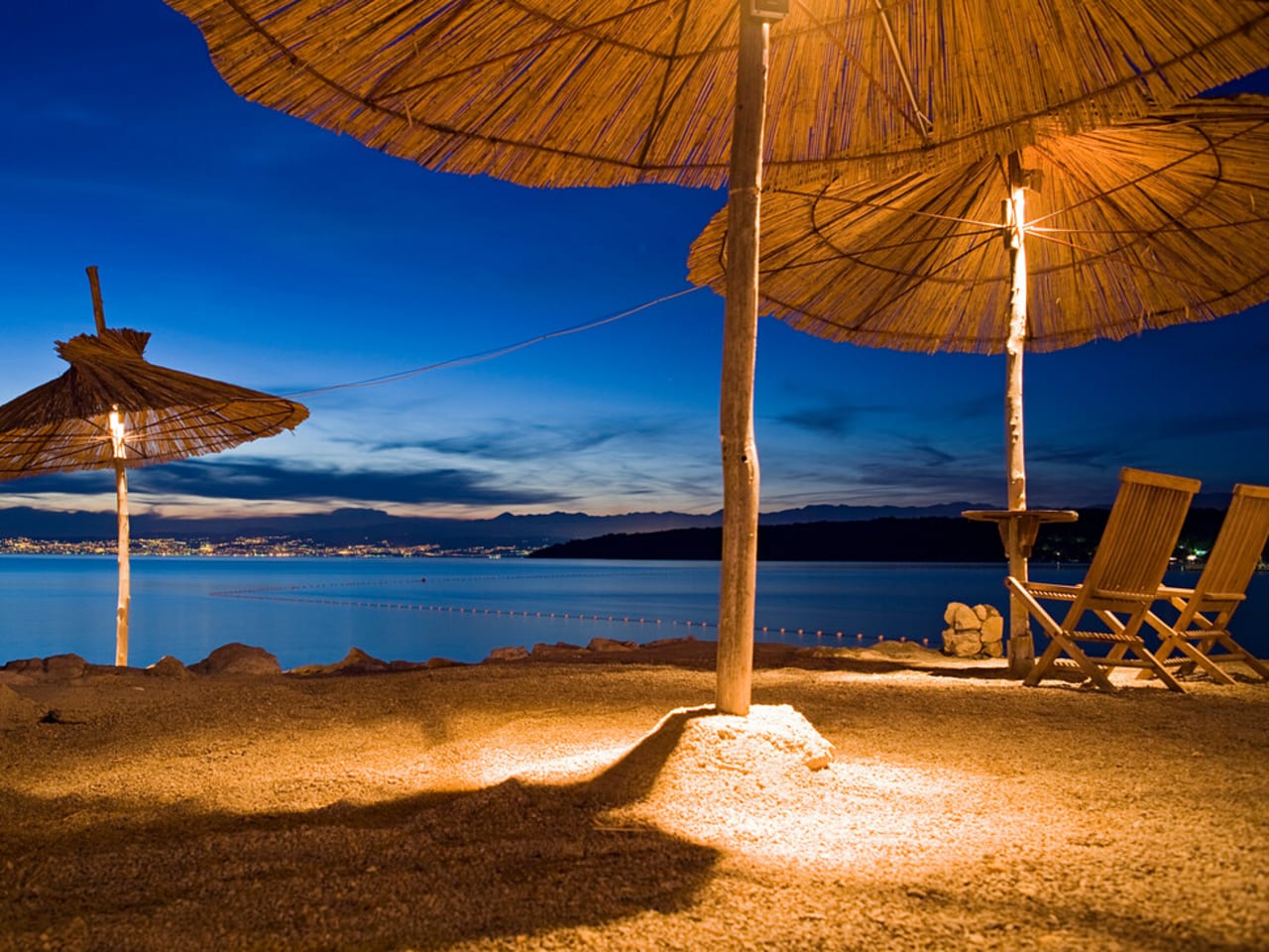 Beleuchtete Sonnenschirme in einer Strandbar, Njivice, Kvarner Bucht, Insel Krk, Kroatien, Europa