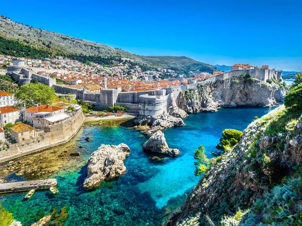 Blick auf die Stadt Dubrovnik mit ihrer Stadtmauer auf der Felsküste © iStock.com/Dreamer4787