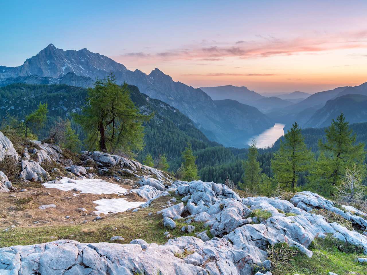 Blick auf ein Gebirge mit Bäumen bei Sonnenuntergang