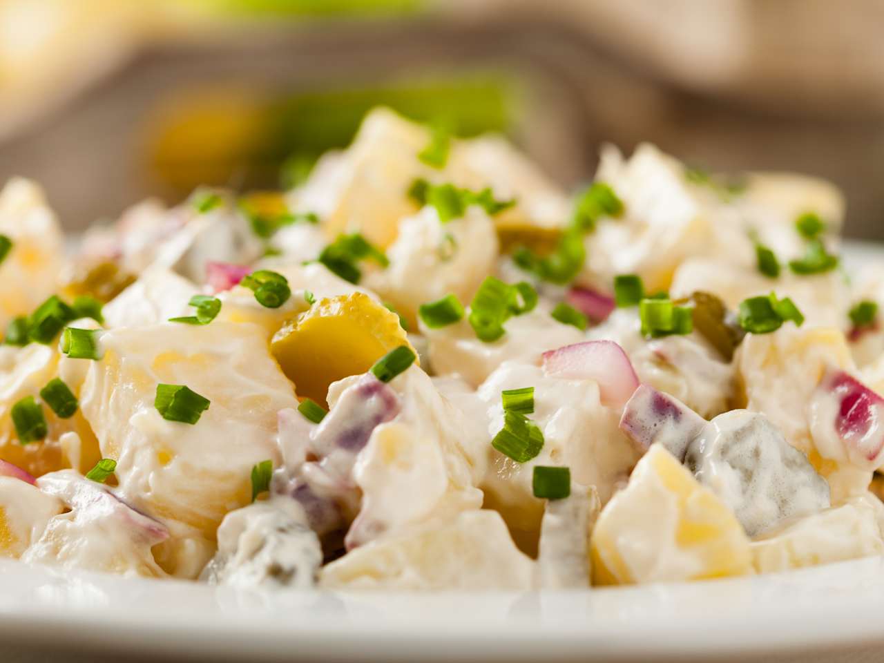 Eine Schüssel voller deutscher Kartoffelsalat mit Mayonnaise.