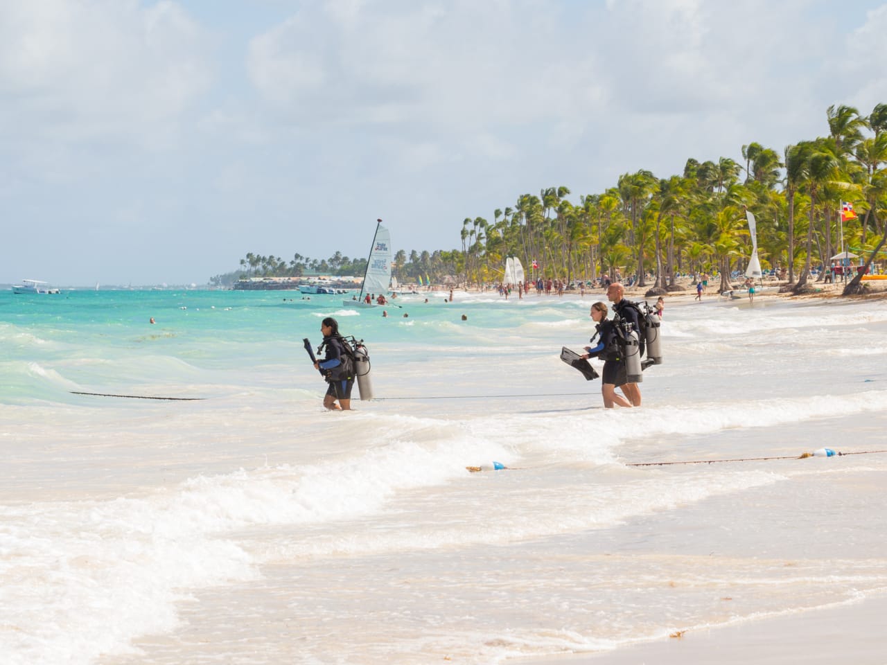 Eine Gruppe von Menschen, die zum Tauchen ins Meer gehen © iStock.com/ico_k-pax