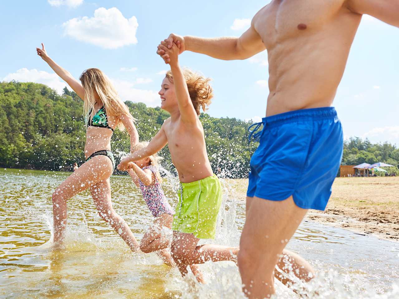 Familie läuft ins Wasser an einem See