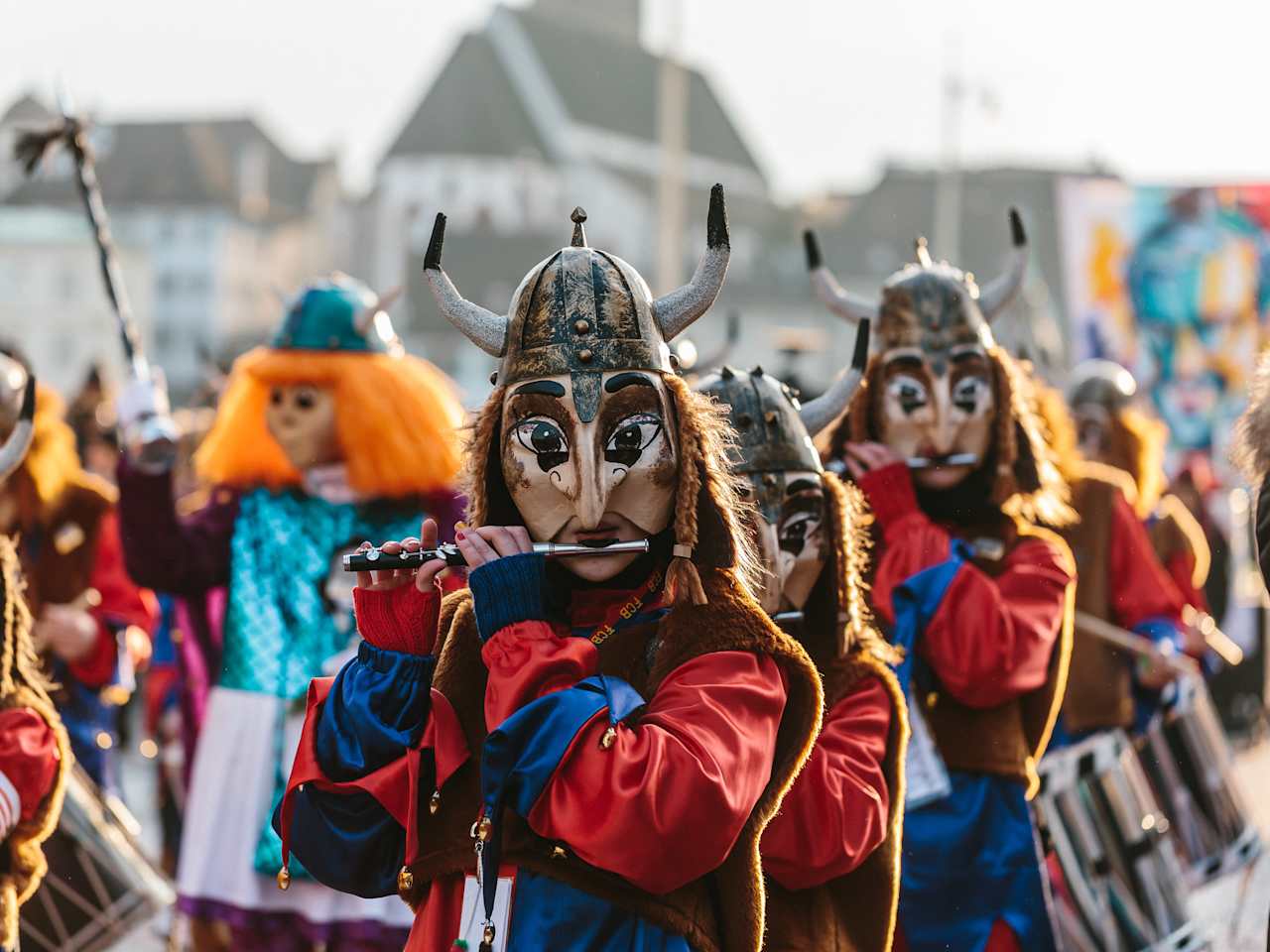 Ein verkleideter Karnevals-Verein zieht durch Basel und spielt auf Querflöten.