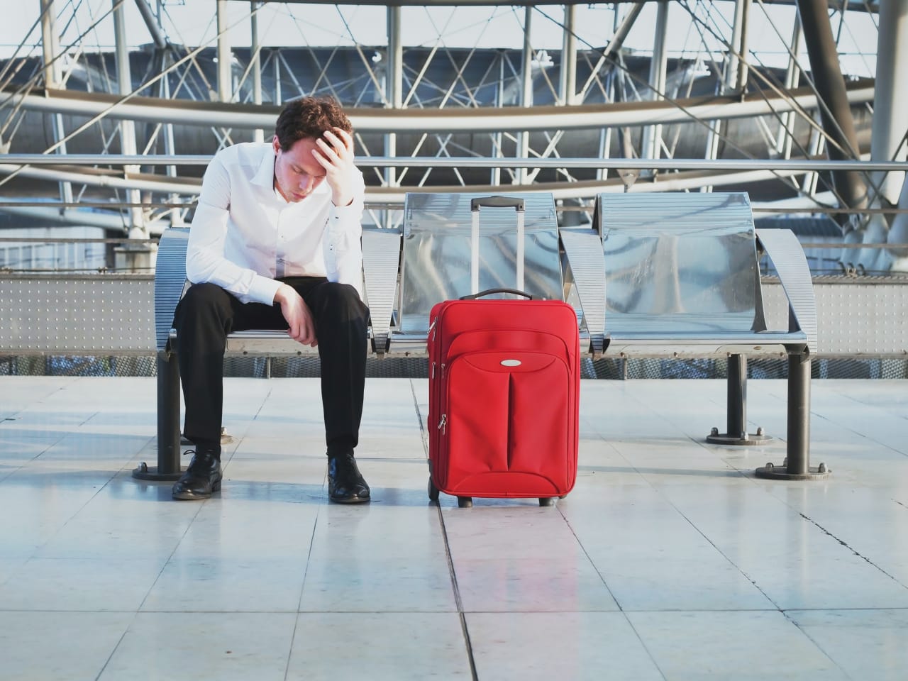Wegen Flugverspätung oder Problem auf dem Flughafen wartet ein müder Passagier am Terminal ©iStock.com/anyaberkut