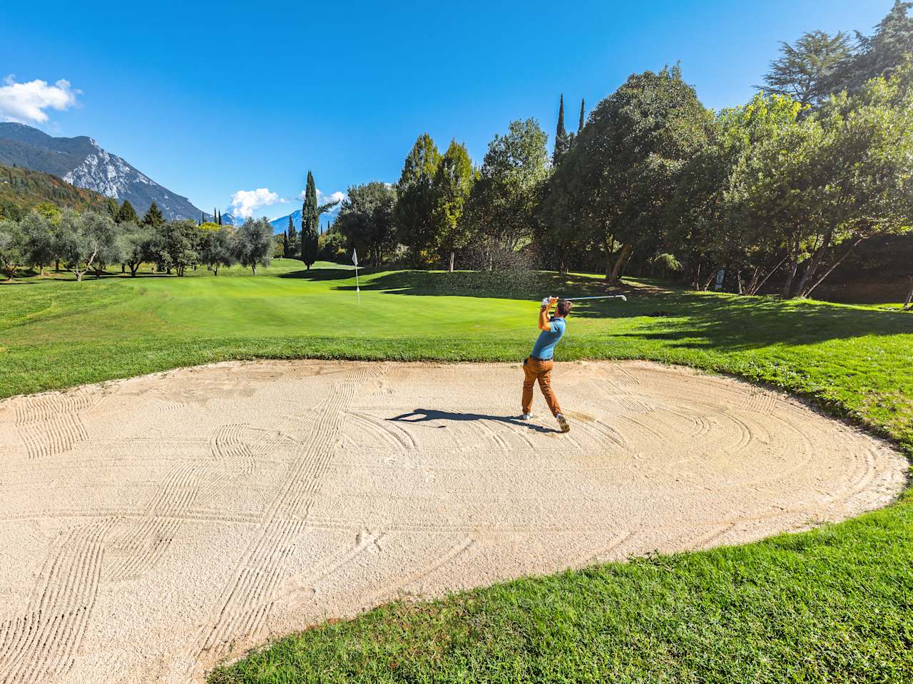 Ein Mann beim Abschlag aus einer Sandgrube