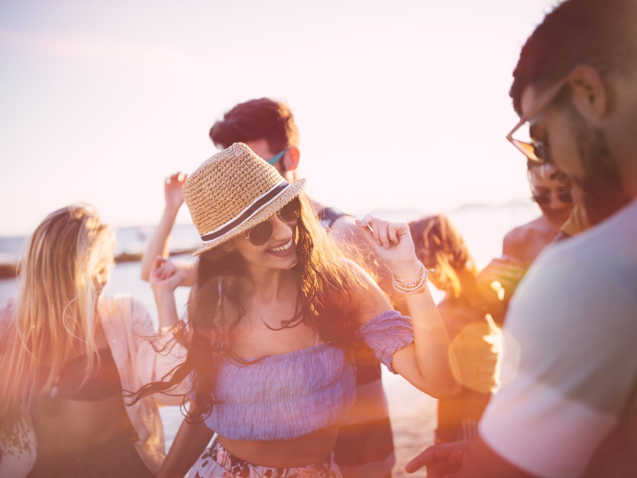 Junge Freunde die Spaß haben bei einer Strandparty bei Sonnenuntergang © iStock.com/wundervisuals