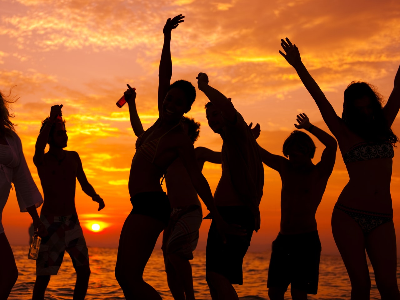 Gruppe beim Tanzen bei Sonnenuntergang