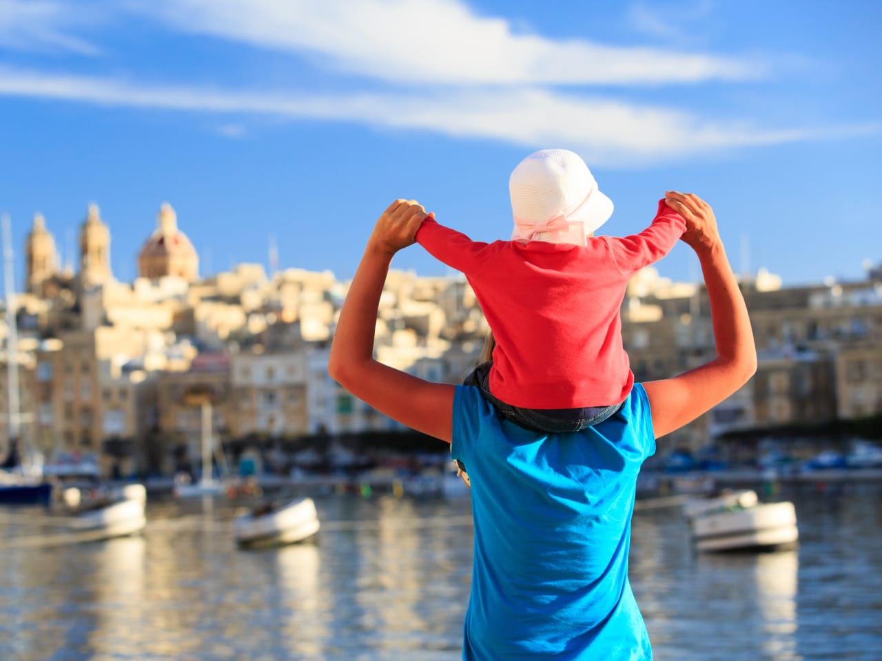 Mutter und Tochter spielen auf dem Kai von Malta mit Blick auf die Stadt und den Hafen © iStock.com/Nadezhda1906