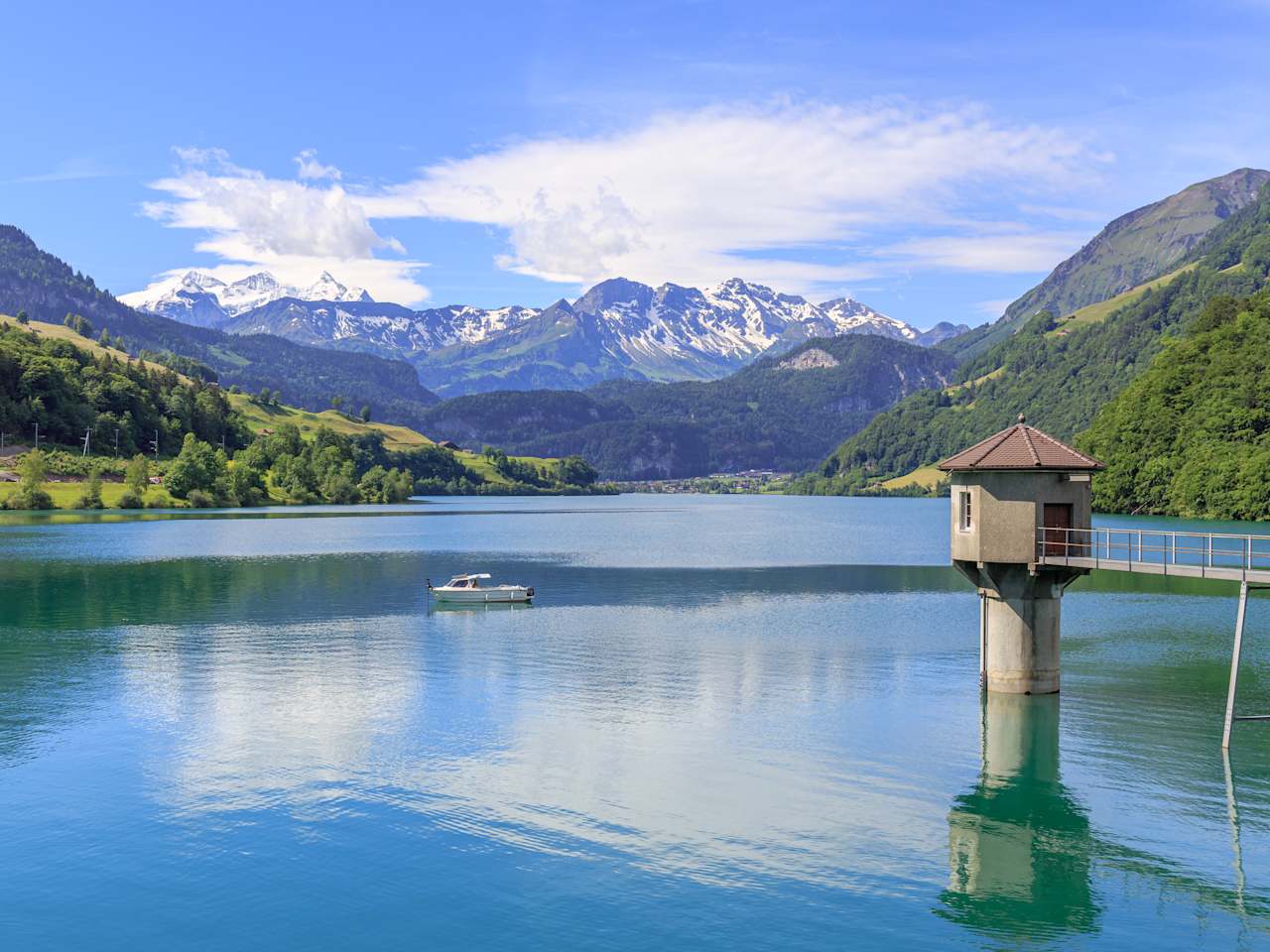 See mit Boot und Bergen im Hintergrund