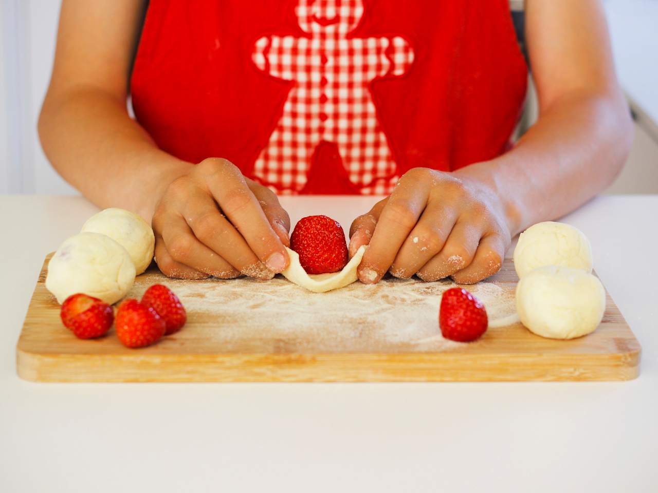 Eine Frau arbeitet Erdbeeren in Knödel ein für die süßen, fruchtigen tschechischen Knödel Ovocné knedlíky.