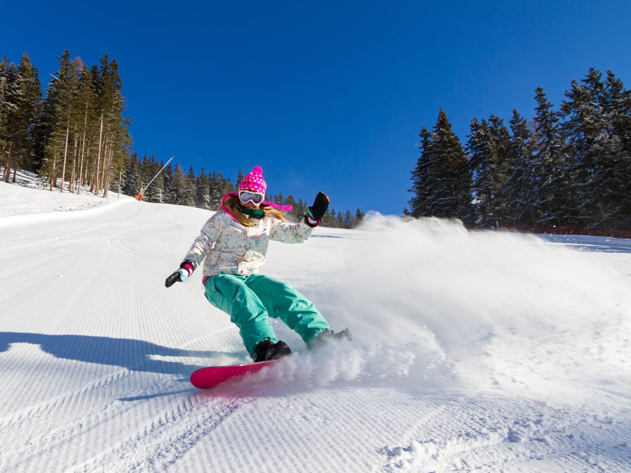 Snowboarderin auf der Piste an einem sonnigen Morgen in den italienischen Alpen © iStock.com/dennisvdw