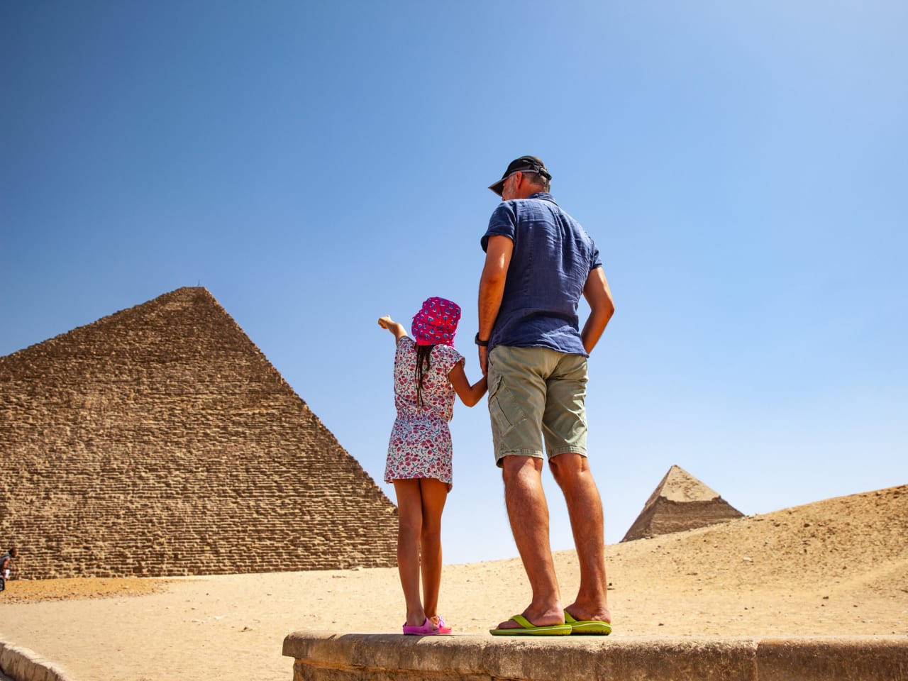 Vater und Tochter betrachten Cheops Pyramide in Gizeh © iStock.com/CasarsaGuru