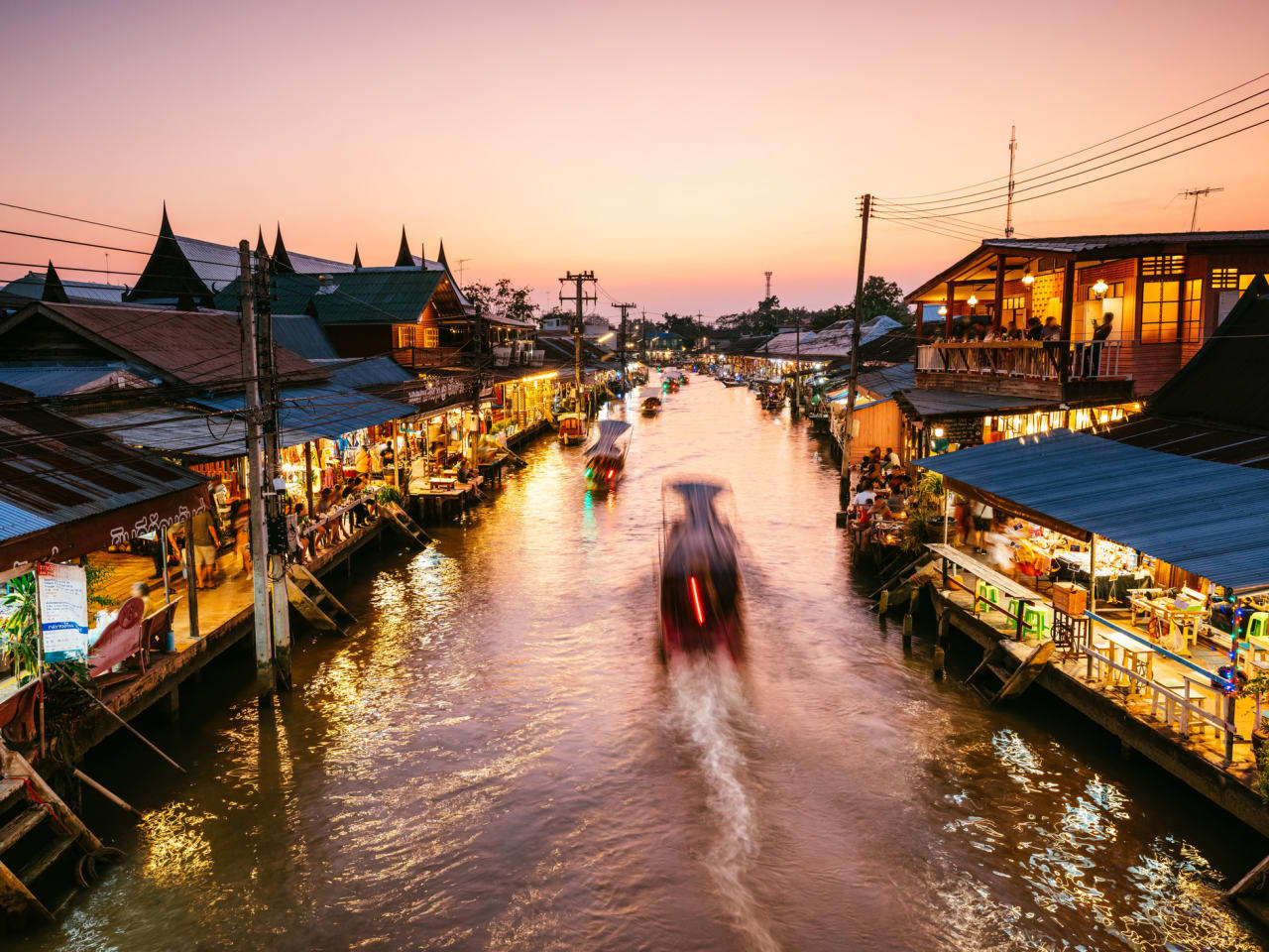 Ein schwimmender Markt in Bangkok, Thailand, im Sonnenuntergang.