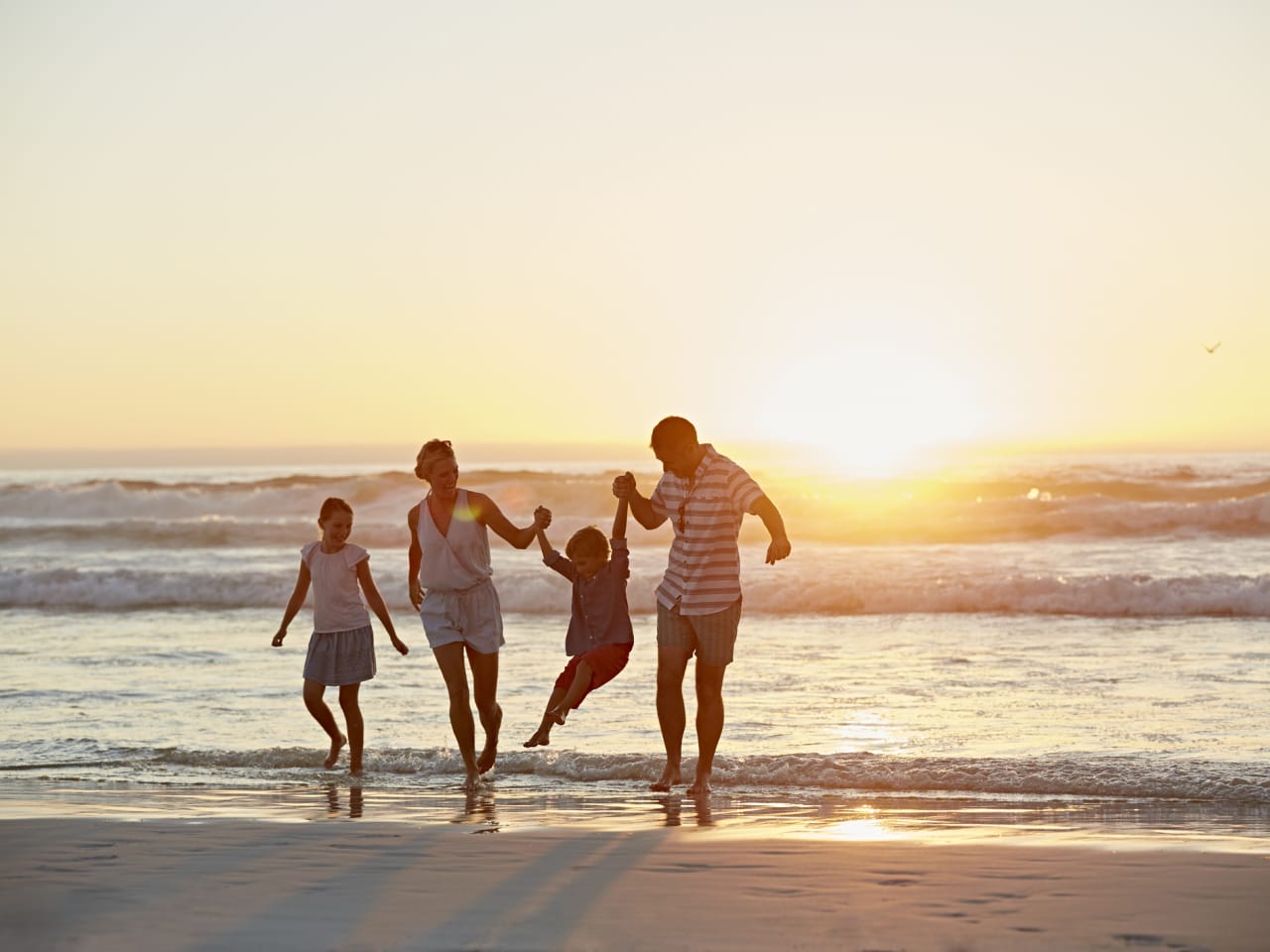 Eine Familie beim Sonnenuntergang am Strand.