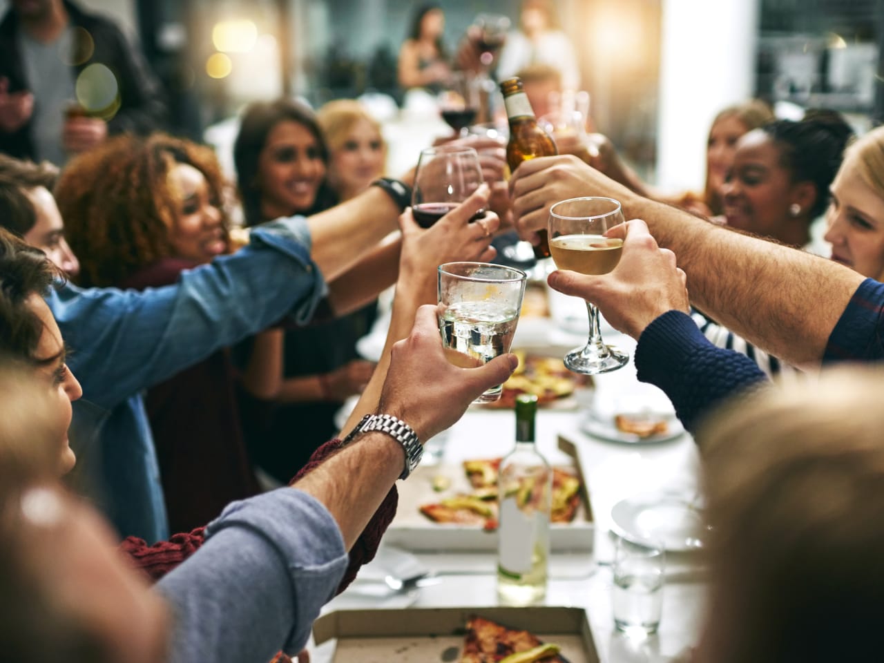 Eine Gruppe von Menschen stößt in einem Restaurant an.