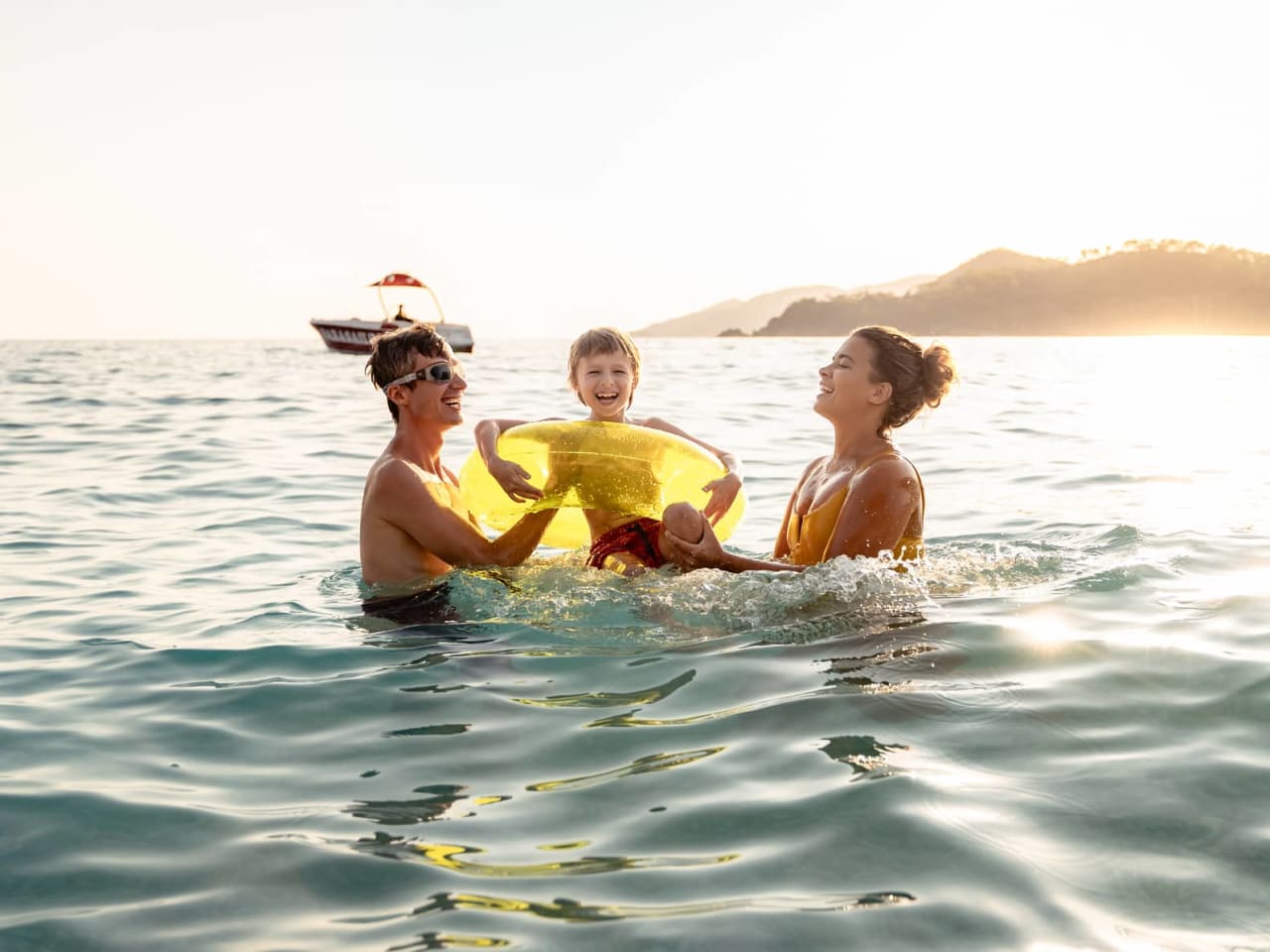 Eine Familie planscht glücklich im Meer.