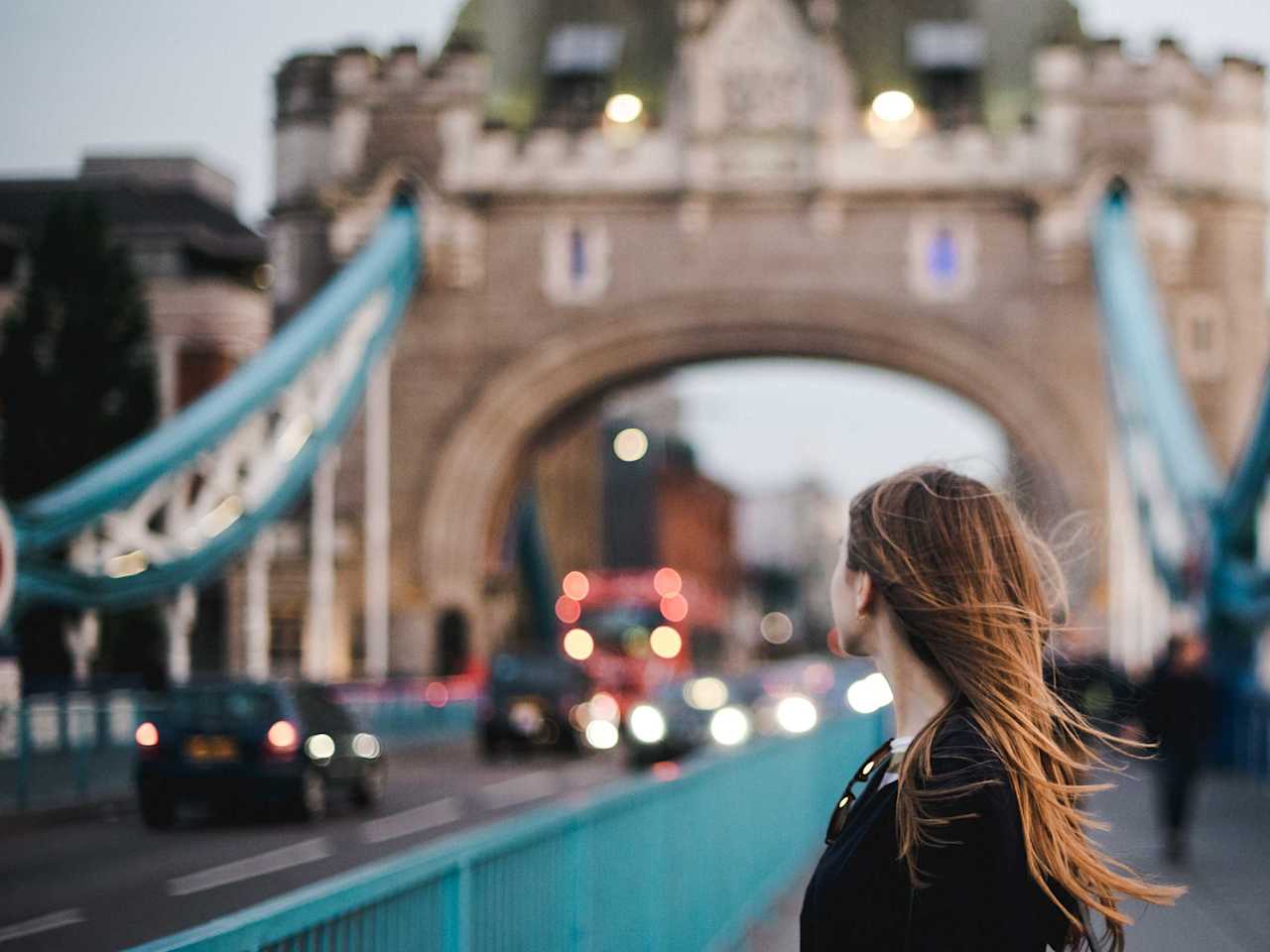 Eine junge Frau steht auf der Tower Bridge in London.