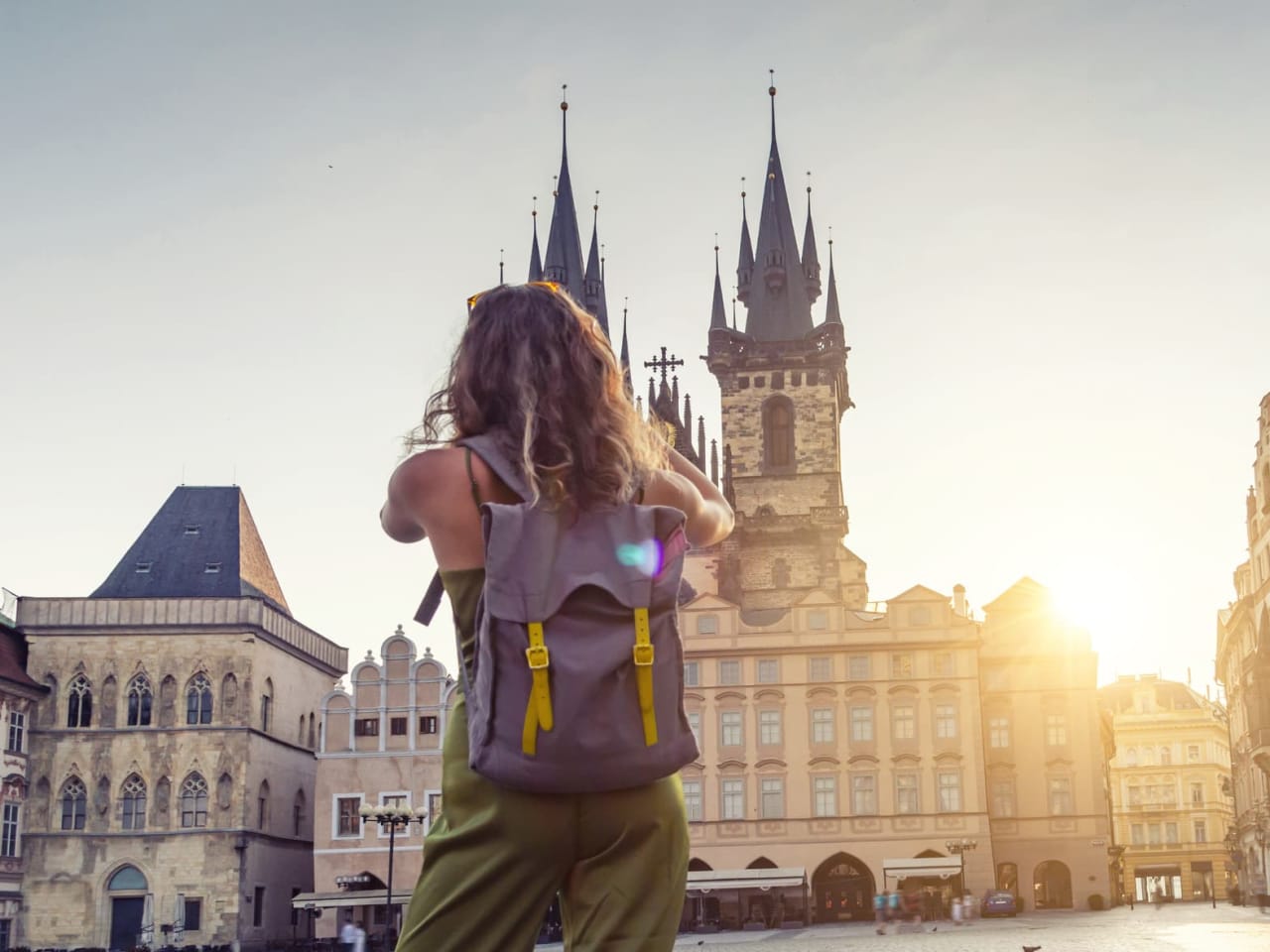 Eine junge Frau macht ein Foto der Tyn Kirche in Prag.