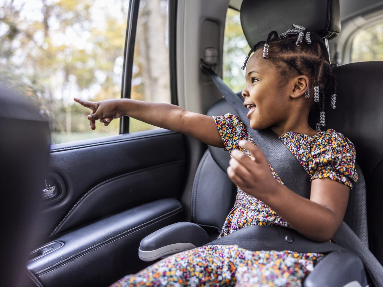 Junges Mädchen schaut aus dem Fenster auf dem Rücksitz eines Autos. © MoMo Productions/DigitalVision via Getty Images
