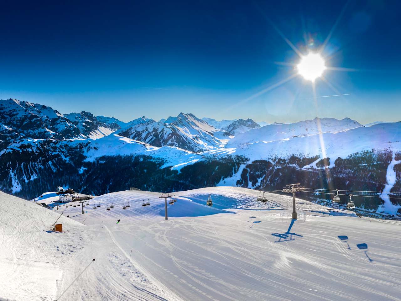 Blick auf einen Skilift zwischen verschneiten Bergen