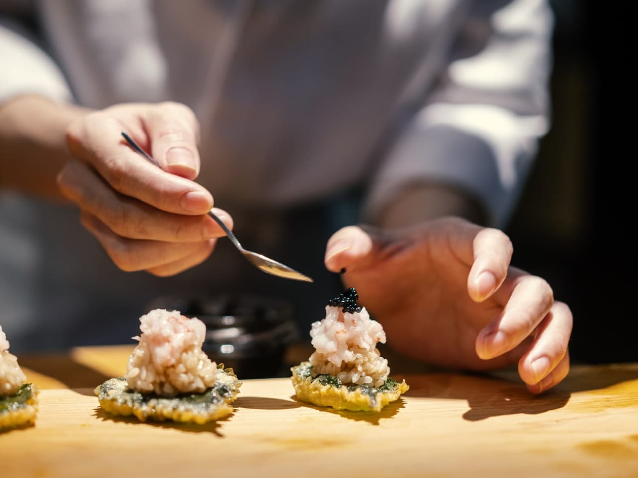 Ein Koch bereitet Sushi zu.