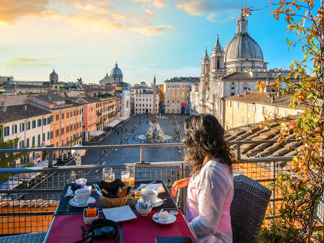 Eine Frau an einem Tisch blickt auf einen Platz