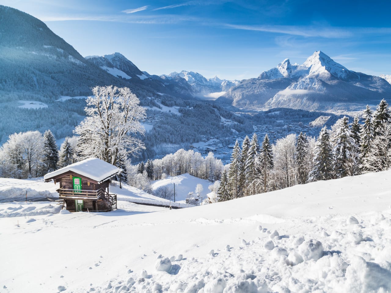 Panoramablick auf die Bergwelt mit einer Hütte in den Alpen.