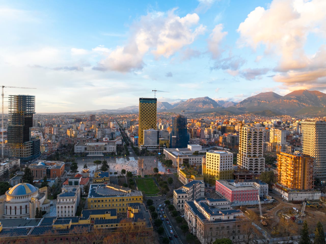 Blick über die Skyline von Tirana mit Bergen im Hintergrund.