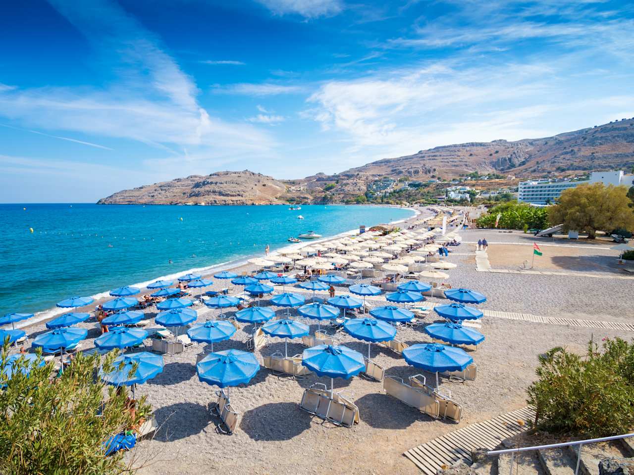 Ein weiter Strand mit blauen Sonnenschirmen