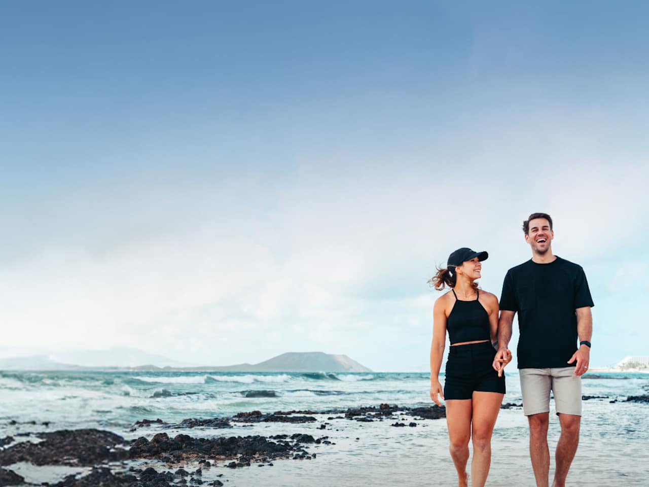 Ein Paar geht am Strand spazieren.