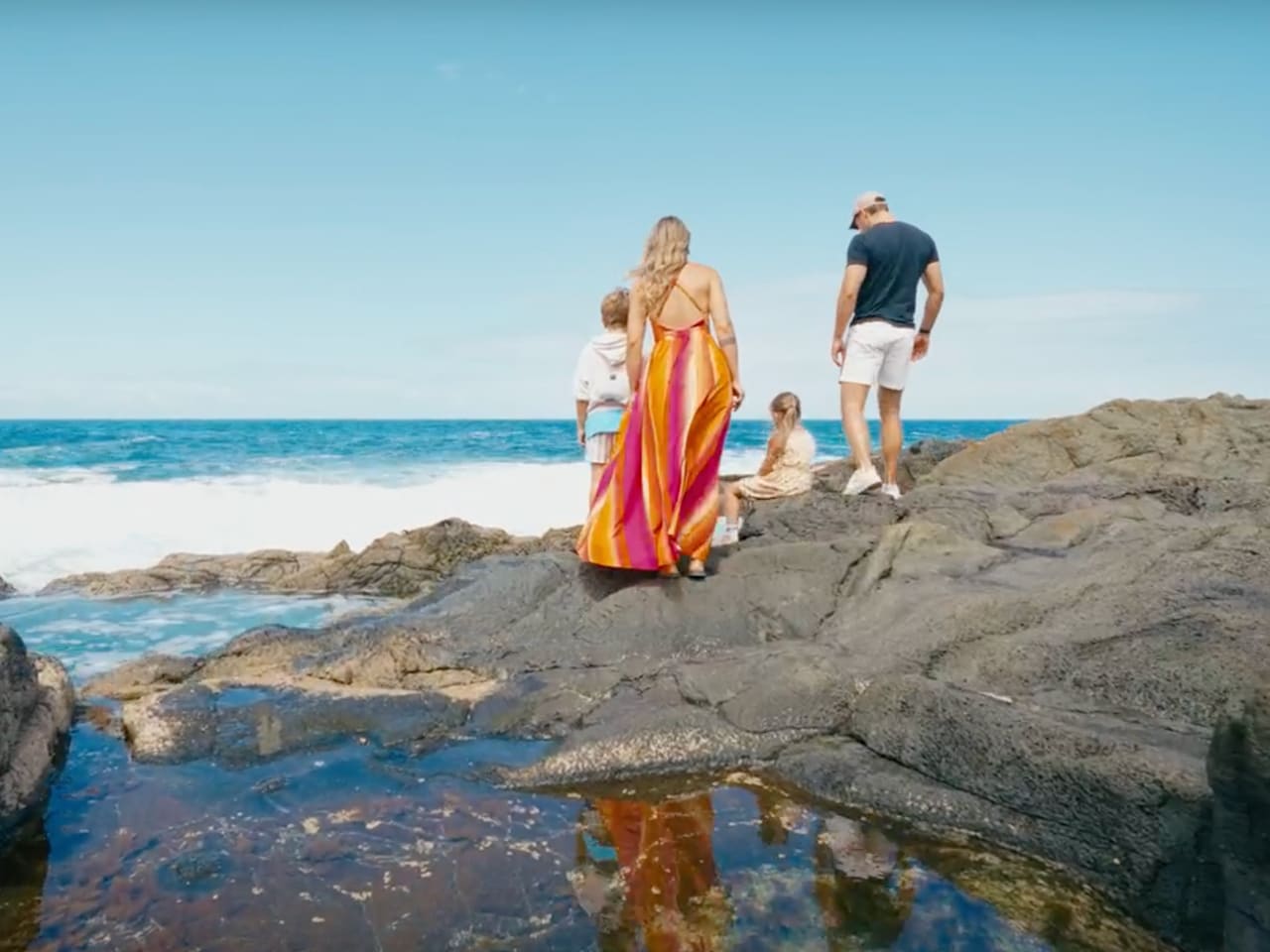 Mutter, Vater und zwei Kinder an einem steinigen Strand auf Fuerteventura, Kanaren.