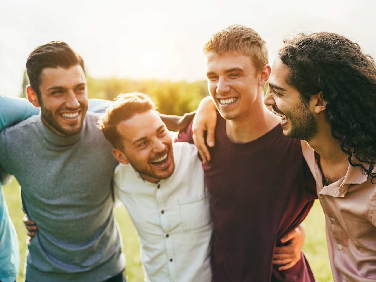 Fröhliche Männer stehen Arm in Arm zusammen.