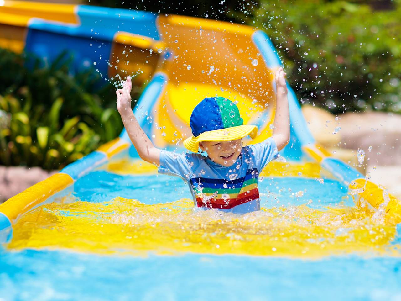 Kleinkind beim Rutschen im Wasserpark  © Getty Images - FamVeld