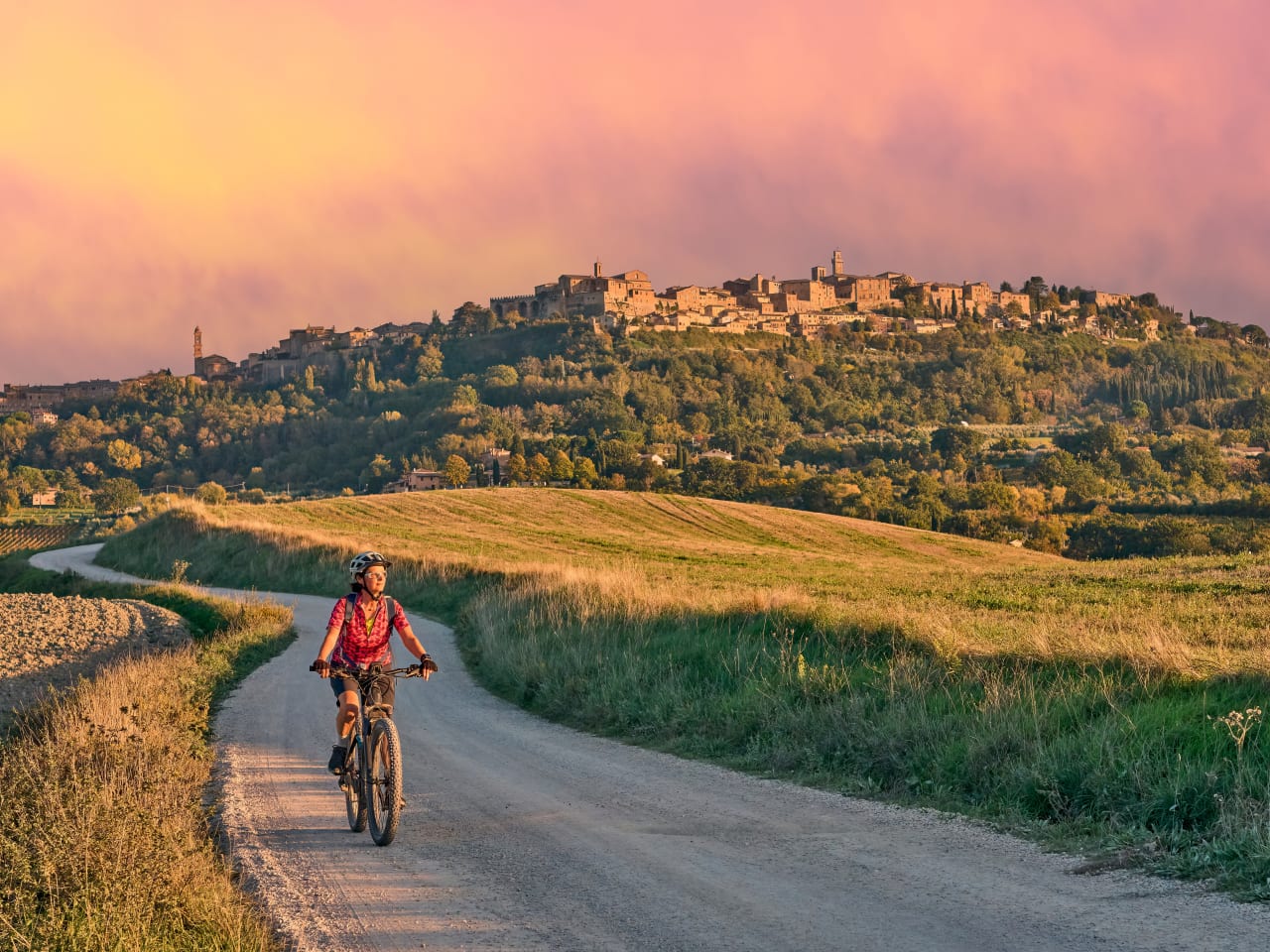 Frau fährt mit Fahrrad durch die Toskana, Italien.
