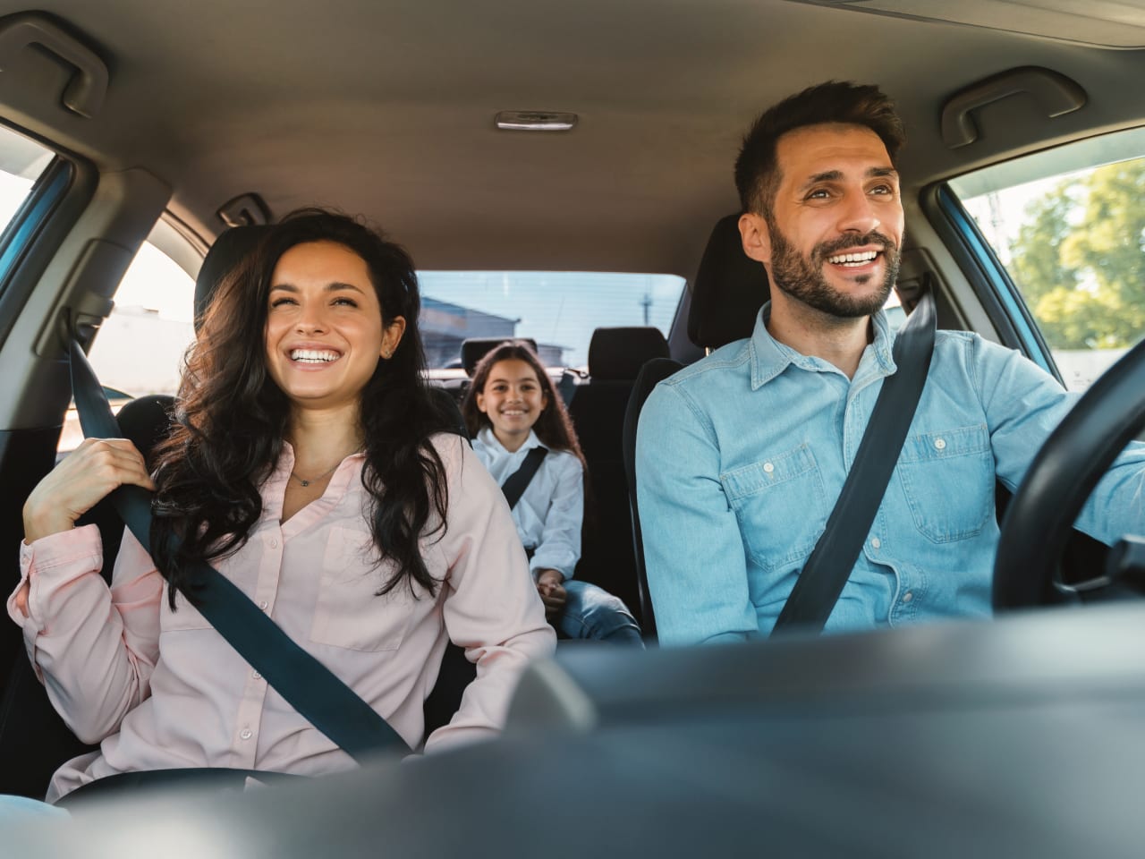 Familie sitzt gut gelaunt im Auto.