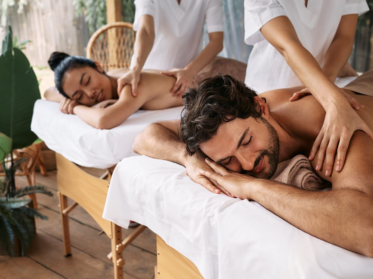 Mann und Frau lassen sich im Wellnessurlaub den Rücken massieren.