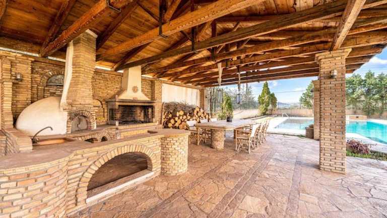 Covered outdoor kitchen and traditional oven