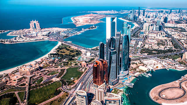 Schöne Hochwinkelsicht auf moderne Wolkenkratzer in Abu Dhabi, von einem Hubschrauber aus. © EXTREME-PHOTOGRAPHER via Getty Images