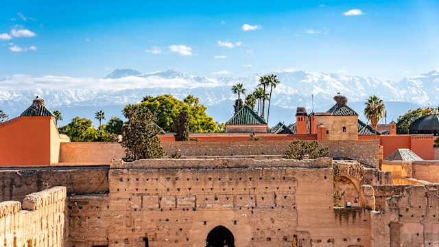 Alte Mauern in Marrakesch mit Bergen im Hintergrund.