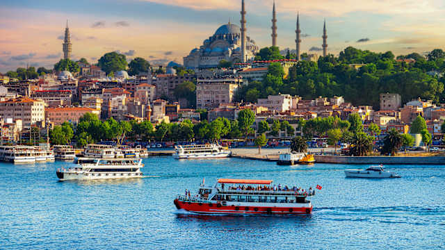 Schiffe auf dem Wasser vor einer Moschee.