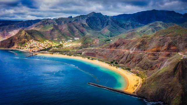Blick auf die Küste der paradiesischen Insel Teneriffa mit kristallklarem, türkisfarbenem Wasser und blauem Himmel mit Drohne, Strand Teresitas, Teneriffa, Spanien. © Eduardo R via Getty Images